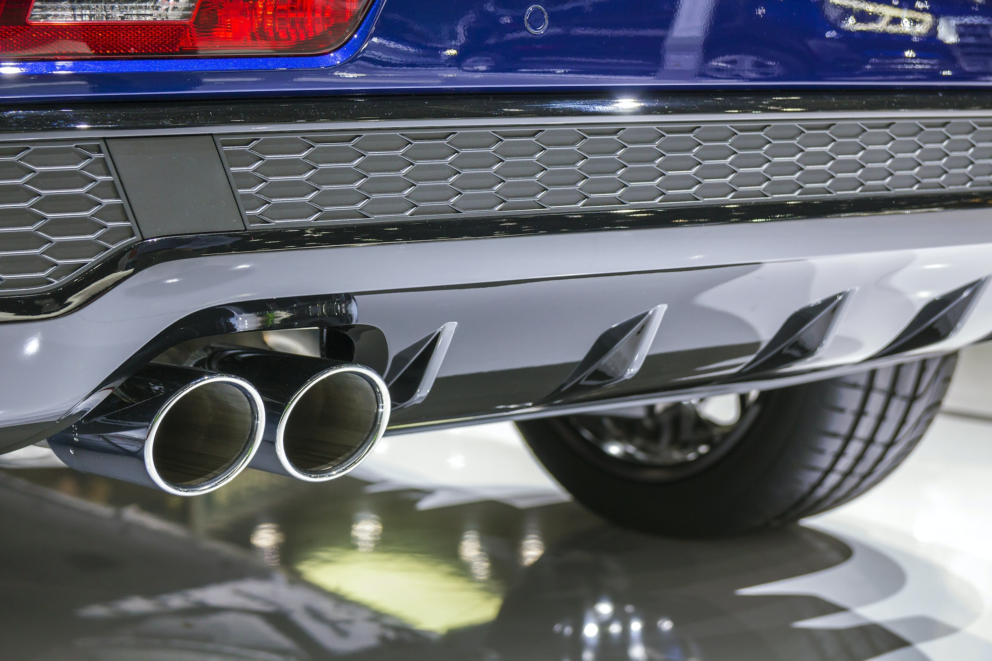 Double chrome exhaust pipe of powerful sport car with grey plastic details